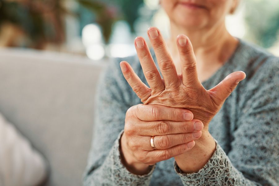 Stock photo of mature woman  massaging hand due to arthritis